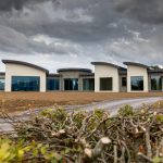 ICF Bow house complete with its curved powder coated facias and stone covered round entrance hall with floor to ceiling windows.